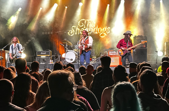 A group of musicians standing on top of a stage