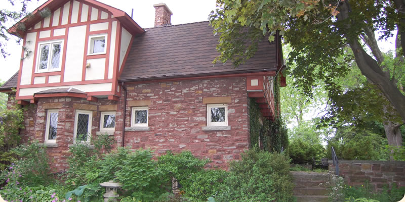 A brick house surrounded by a lush garden