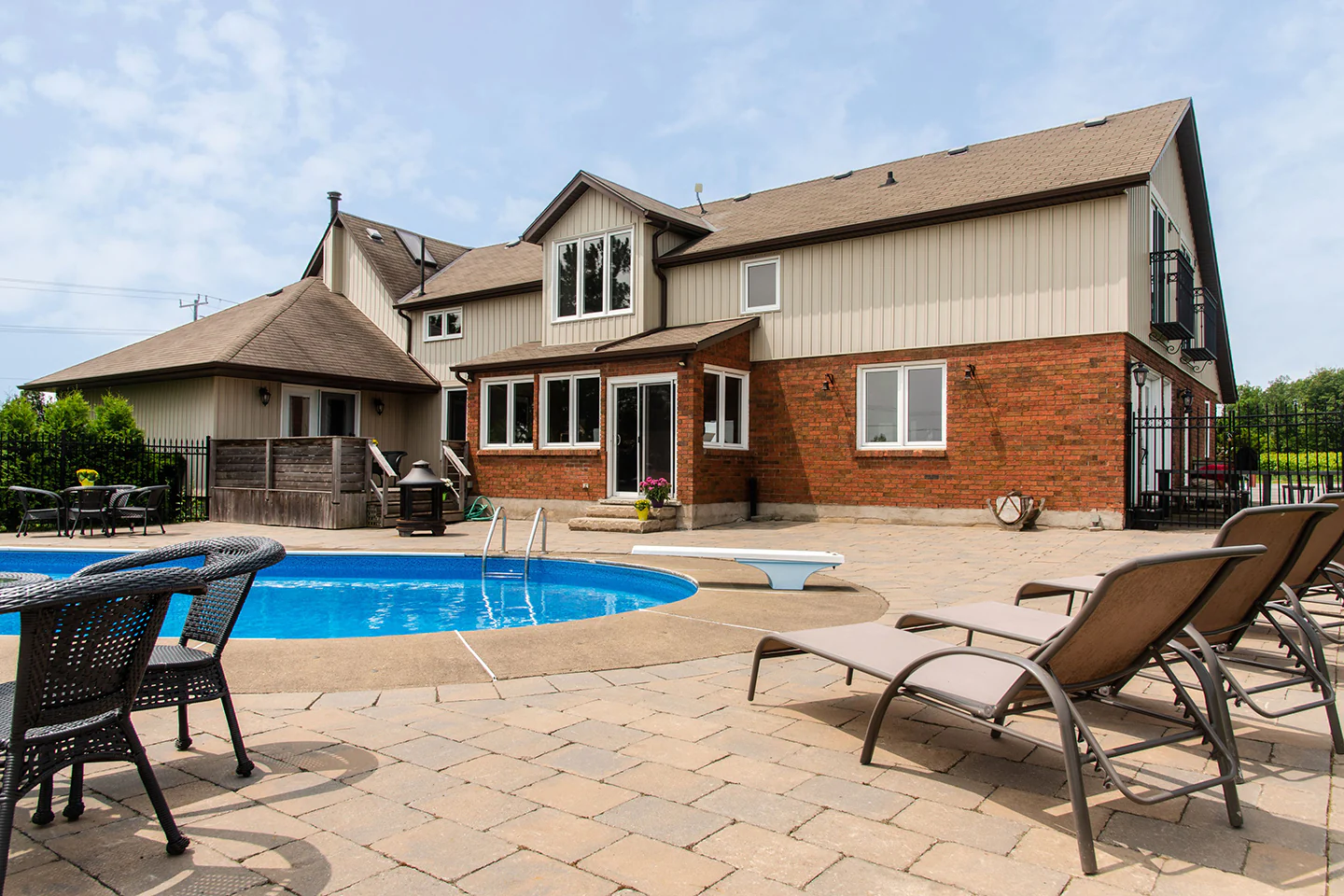 A backyard with a swimming pool and patio furniture