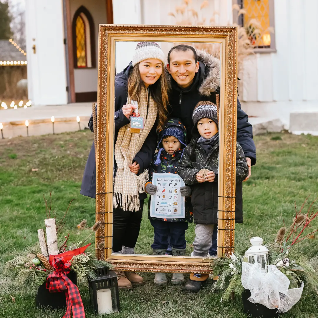 A family standing in front of a picture frame