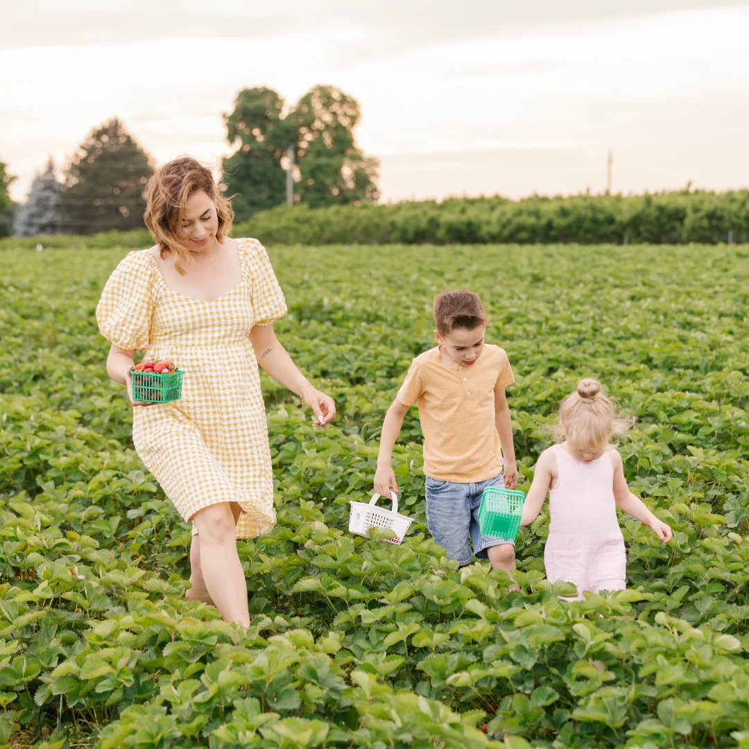 A woman and two children walking through a field