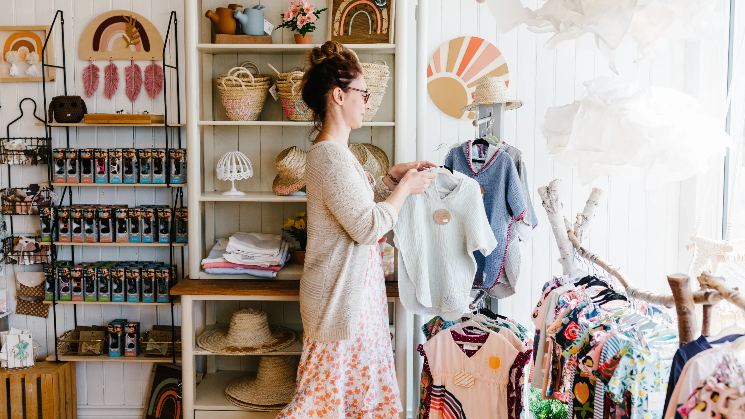 A woman standing in front of a rack of clothing