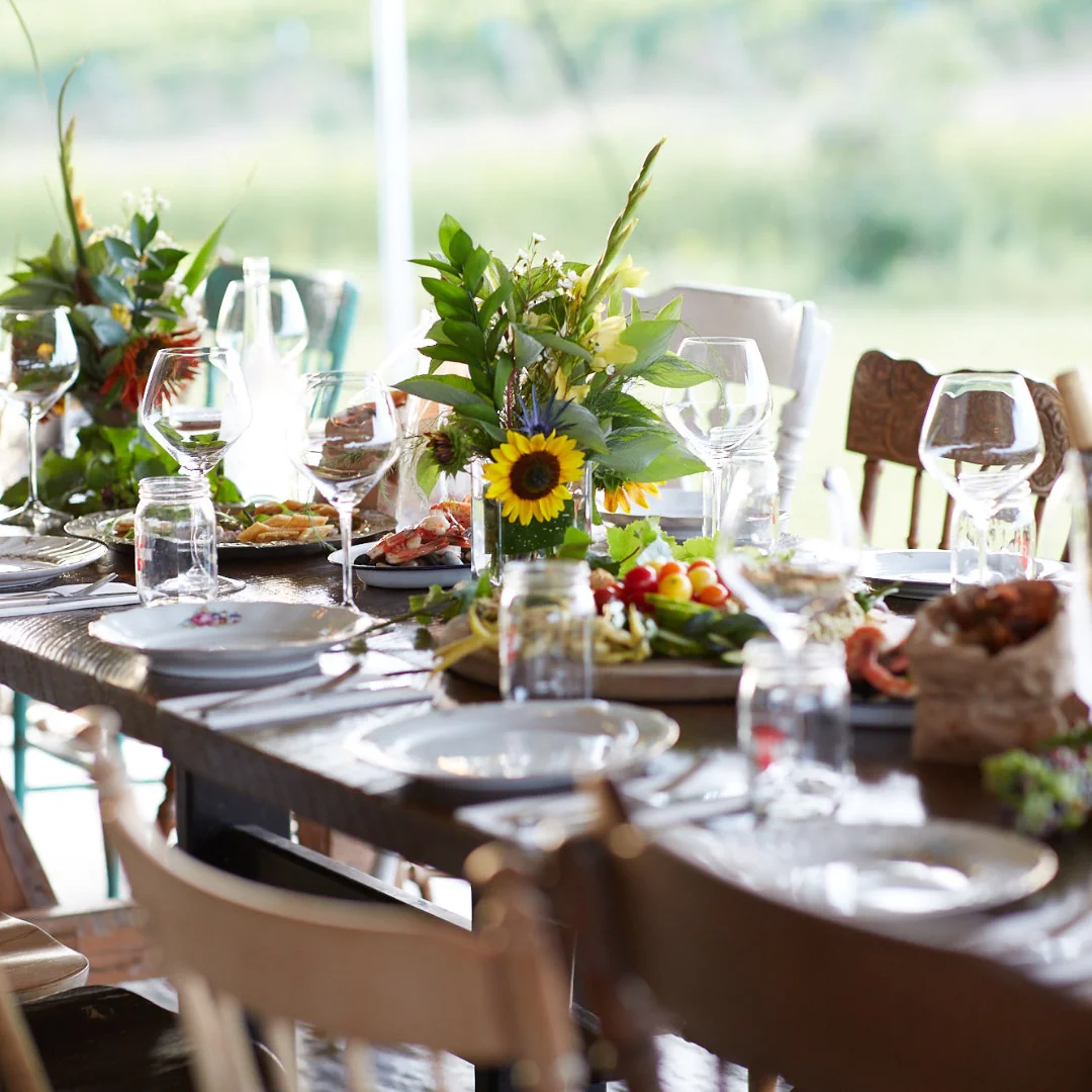 Harvest table set up for an event with flowers as centrepieces