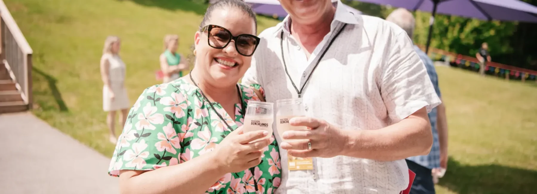 Two people enjoying wine outdoors in Canada’s premier wine region, savouring exceptional flavours crafted by local winemakers.