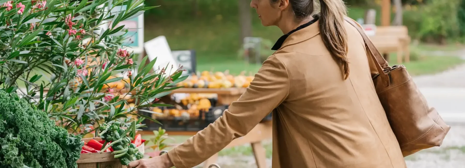 A woman exploring an outdoor farmers market along the CultivATE Taste Trail, savouring the region’s fresh flavours and fragrances.