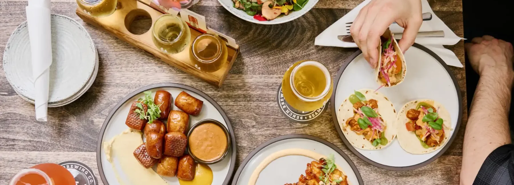 A table full of delicious food showcasing a bounty of local flavours, set against a backdrop of gardens and grapevines.